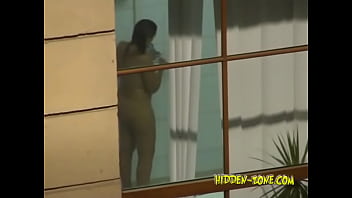A Girl Washes In The Shower, And We See Her Through The Window
