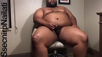 Black Man In Tan Desk Chair In Hotel Room.