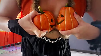 Halloween 2021 Witch In A Sexy Red Suit. Red-haired Witch With Pumpkins And A Broom. Regina Noir