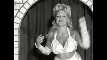 Curly Blonde With Huge Tits Takes Part In An Erotic Performance Of The 60s