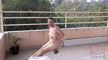 The Lady Is Swinging On A Rope Swing, Hiding From The Rain Under An Umbrella.